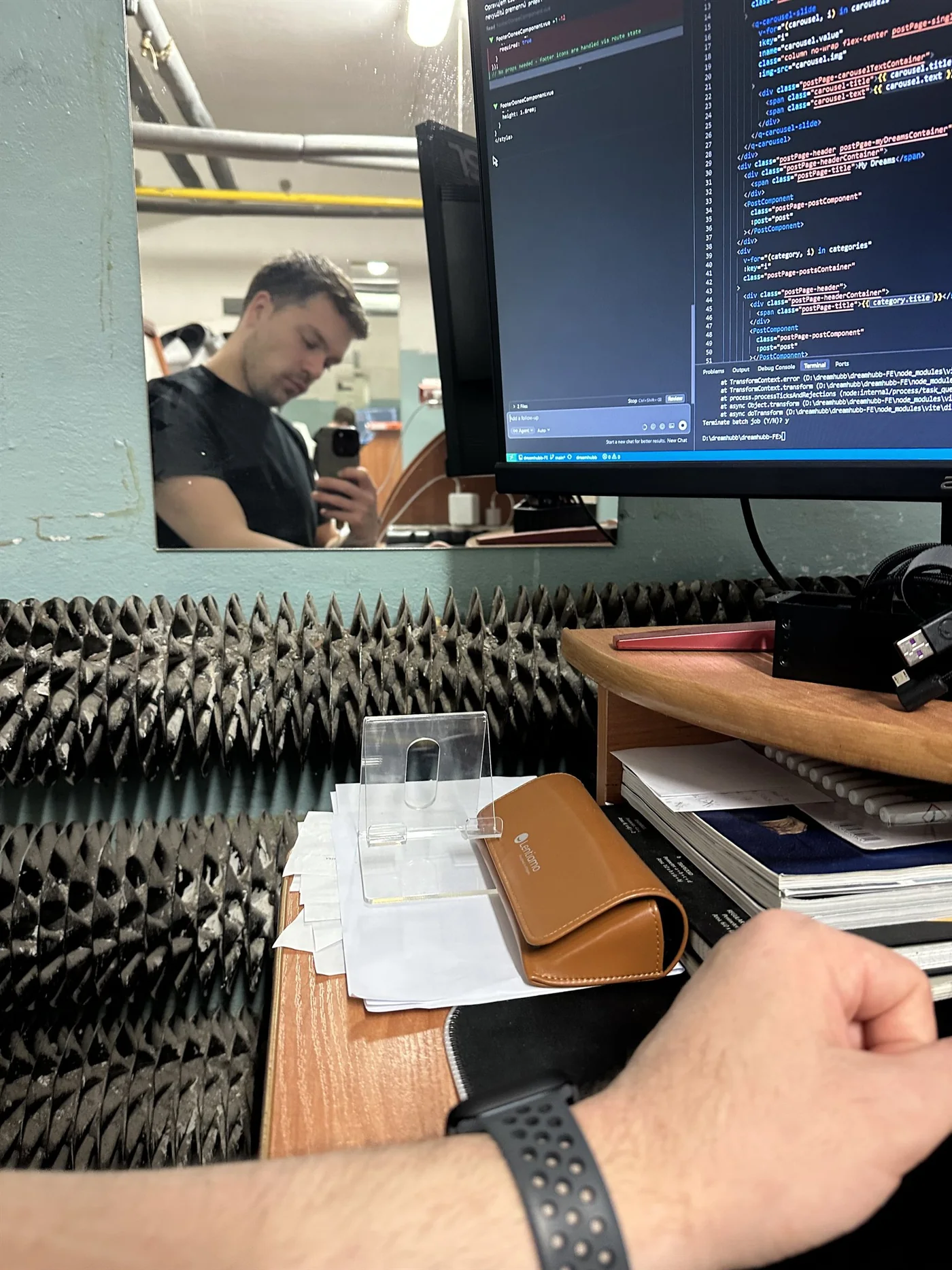 A detail of dreamhubb code and Matej reflected in the basement workspace mirror