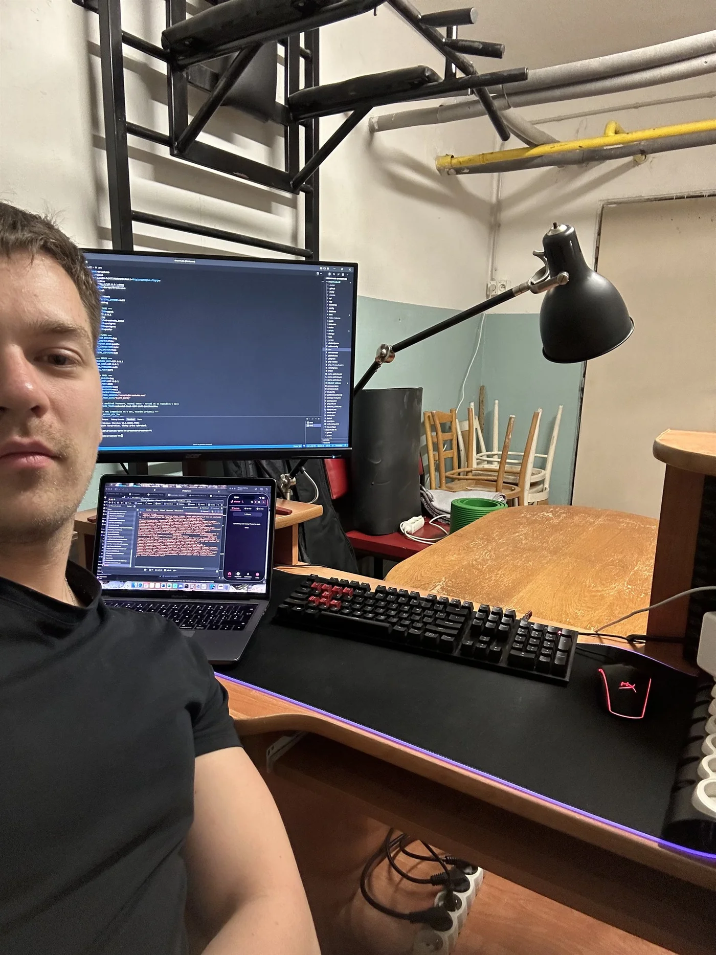 Matej at an improvised workstation with a laptop, monitor and dreamhubb in progress